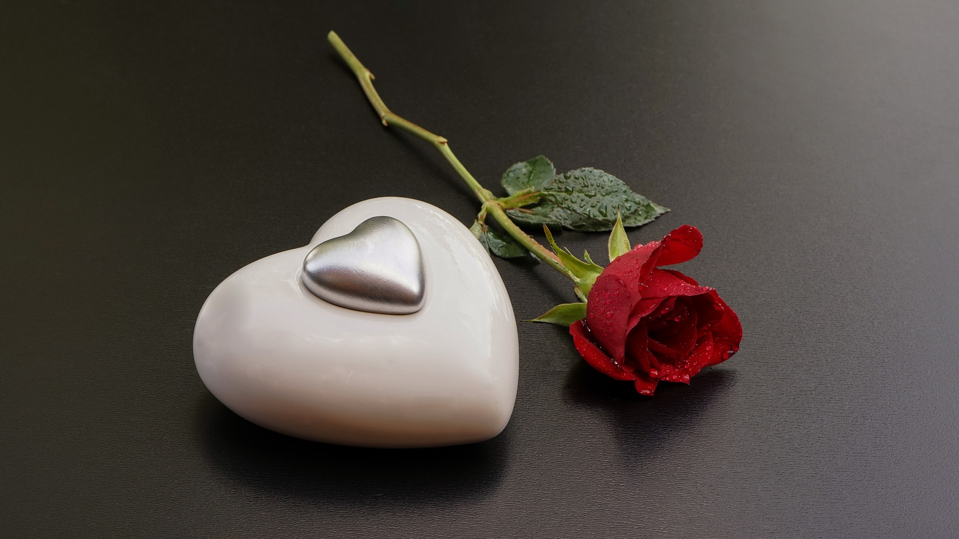 stone heart and rose on table